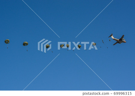 Parachute members escaping one after another from the transport aircraft at the beginning of descent training 69996315