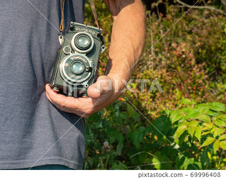 Old photographer use analog camera. Senior man relax 69996408