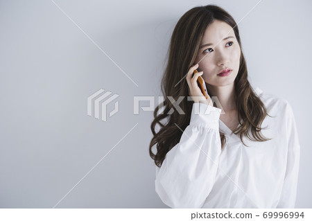 Woman using a smartphone Woman using a smartphone 69996994