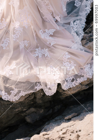 Close-up of the train of a bride dress on a stone texture. 69997083