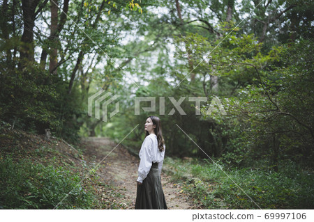 Woman in a green park Woman in a green park 69997106