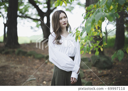 Woman in a green park Woman in a green park 69997118