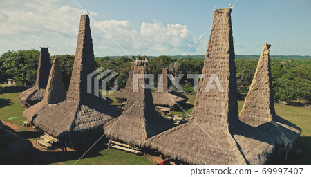 Aerial closeup view of traditional village with ornately roofs cottages. Tropical landscape at homes 69997407