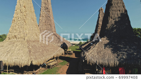 Closeup traditional village houses roofs at green countryside of Sumba Island Closeup traditional village houses roofs at green countryside of Sumba Island 69997408