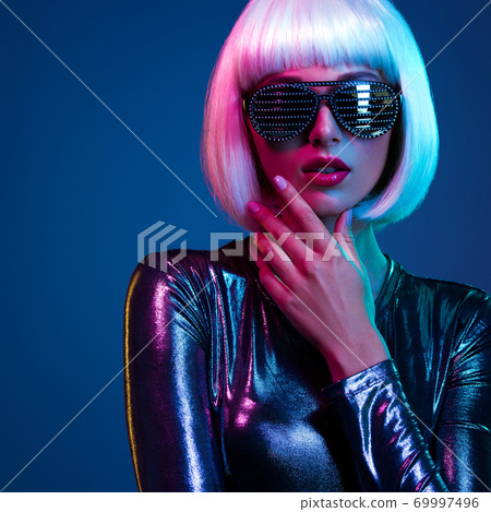 Stylish blonde in shiny dress and sunglasses with stresses. Closeup face of beautiful fashionable woman in white wig. Art portrait of an young attractive model. Fantasy style. Glamour fashion girl Stylish blonde in shiny dress and sunglasses with stresses. Closeup face of beautiful fashionable woman in white wig. Art portrait of an young attractive model. Fantasy style. Glamour fashion girl 69997496