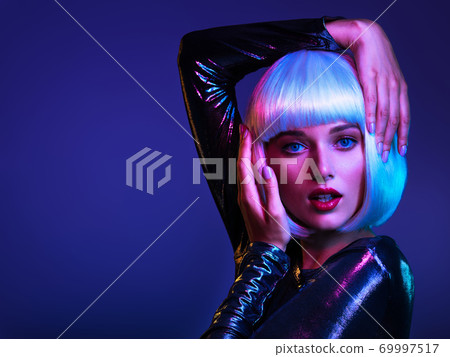 Glamour fashion girl. Beauty face with bright makeup. Young beautiful woman with a bob hairstyle posing at studio. Close up art portrait  of  an young attractive woman with blue background. Stylish 69997517