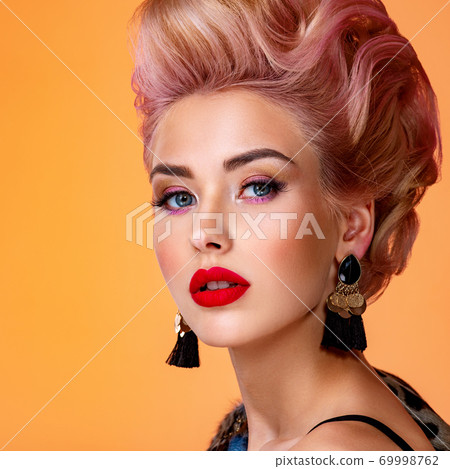 Beautiful woman with creative hairstyle, vivid makeup. Fashionable girl. Beautiful face of young woman with red lips. Stunning blonde girl. Bright eye makeup. Attractive caucasian model with earrings Beautiful woman with creative hairstyle, vivid makeup. Fashionable girl. Beautiful face of young woman with red lips. Stunning blonde girl. Bright eye makeup. Attractive caucasian model with earrings 69998762