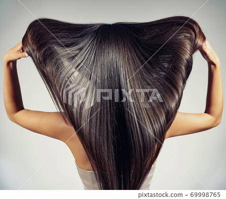 Back view of a brunette woman with a long straight hair. Back view of a brunette woman with a long straight hair. 69998765