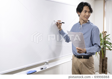 試圖在白板上寫的年輕人(補習班的老師) 試圖在白板上寫的年輕人(補習班的老師) 69998868