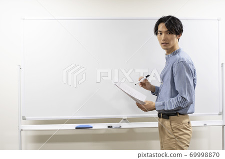 試圖在白板上寫的年輕人(補習班的老師) 試圖在白板上寫的年輕人(補習班的老師) 69998870