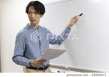 Young man trying to write on the whiteboard (cram school teacher) 69998871