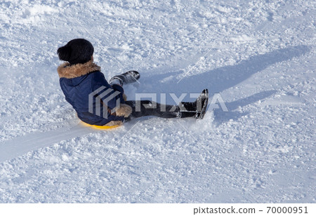 Girl sledding from the mountain in winter Girl sledding from the mountain in winter 70000951