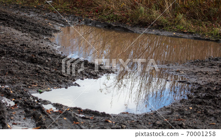 Puddle on a muddy road in autumn Puddle on a muddy road in autumn 70001258
