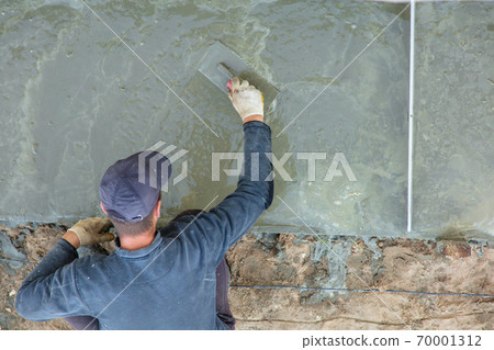 Workers pour concrete solution at a construction site Workers pour concrete solution at a construction site 70001312