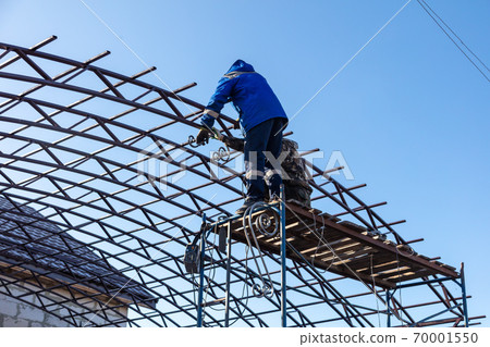 Workers are installing a metal canopy. Workers are installing a metal canopy. 70001550