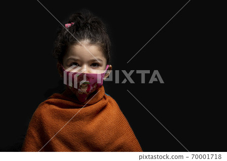 Little girl wearing mask for protection from epidemic coronavirus in front of dark background Little girl wearing mask for protection from epidemic coronavirus in front of dark background 70001718
