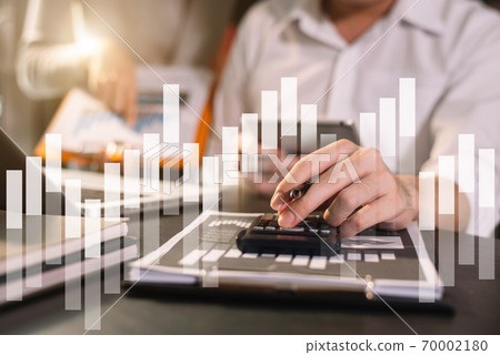 Businessman working on desk office with using a calculator to calculate the numbers, finance concept in office. 70002180