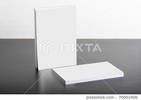 Books with blank cover on dark glossy table 70002406