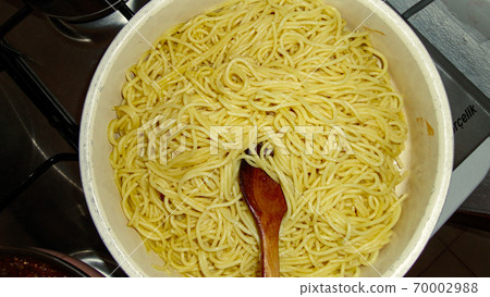 A large bowl with freshly cooked spaghetti and wooden spoon closeup A large bowl with freshly cooked spaghetti and wooden spoon closeup 70002988