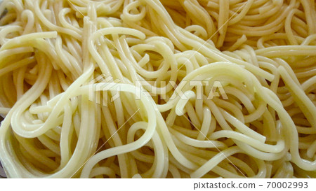 A large bowl with freshly cooked spaghetti and wooden spoon closeup 70002993