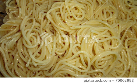 A large bowl with freshly cooked spaghetti and wooden spoon closeup 70002998