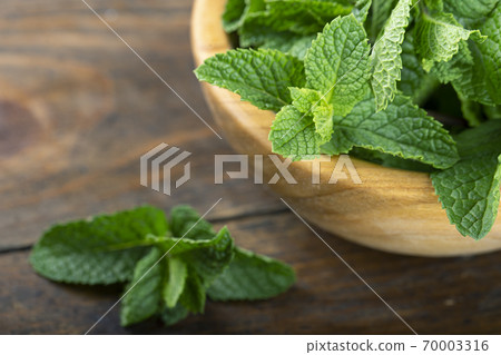 Green fresh mint on the wooden table. Green fresh mint on the wooden table. 70003316