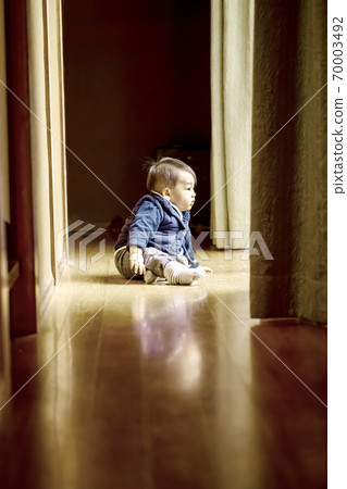 Cute baby looking out the window from the corridor and copy space Cute baby looking out the window from the corridor and copy space 70003492