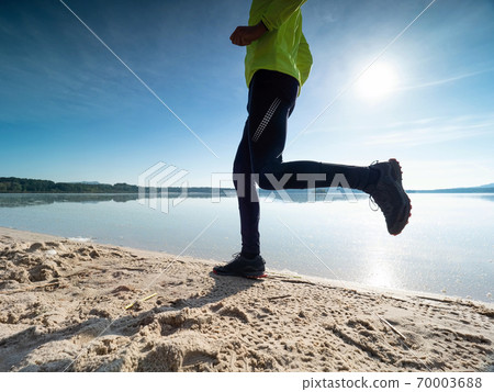 Fit and healthy man in sports clothing jogging outdoors 70003688