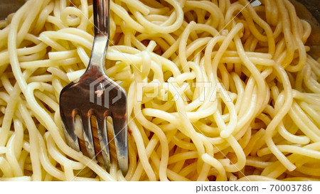 Large bowl with freshly cooked pasta spaghetti and metal fork closeup 70003786