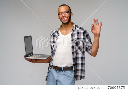 A young african american man working with a laptop pc 70003875