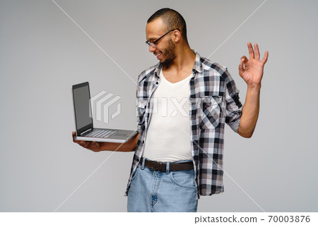 A young african american man working with a laptop pc 70003876