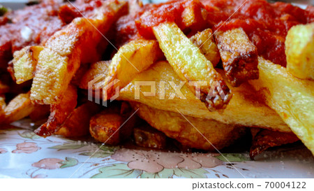 french fries covered with hot organic  tomato sauce closeup in the white plate 70004122