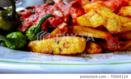 french fries covered with hot organic  tomato sauce closeup in the white plate 70004124