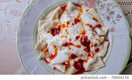 Traditional Turkish cuisine Ravioli, Manti Manlama serving with yogurt and fried butter sauce. Traditional Turkish cuisine Ravioli, Manti Manlama serving with yogurt and fried butter sauce. 70004230