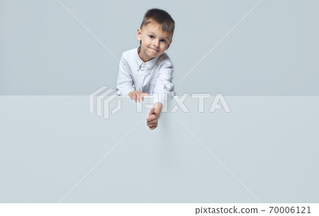 the little boy points to an empty space. thumbs up. white background the little boy points to an empty space. thumbs up. white background 70006121
