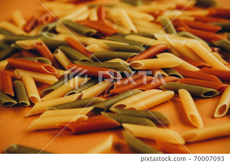 Frame made of colorful green, yellow and red penne pasta naturally coloured with tomato and spinach. Frame made of colorful green, yellow and red penne pasta naturally coloured with tomato and spinach. 70007093