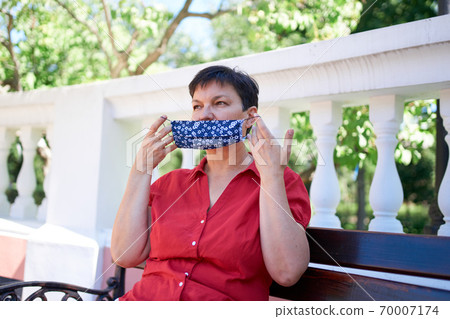 Beautiful mature european woman wearing handmade protective mask Beautiful mature european woman wearing handmade protective mask 70007174