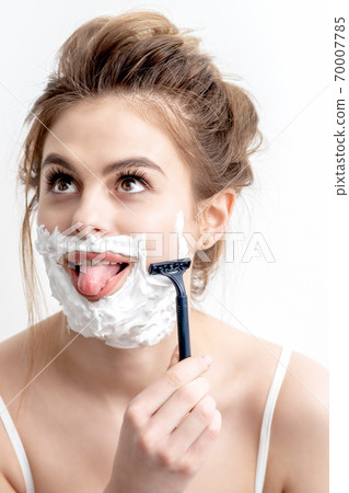 Woman shaving her face by razor 70007785
