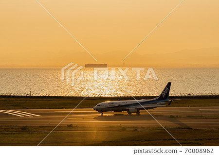 An airplane stained in the sunset 70008962