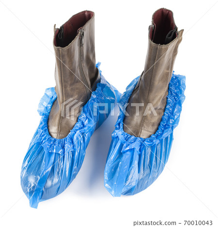 Blue protective shoe covers on female shoes isolated on white background. 70010043