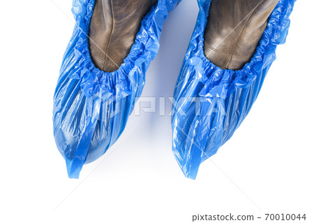 Blue protective shoe covers on female shoes isolated on white background. Blue protective shoe covers on female shoes isolated on white background. 70010044