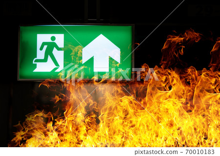 Green fire escape sign hang on the ceiling in the Warehouse. The concept of fire escape training and preparation for evacuation Green fire escape sign hang on the ceiling in the Warehouse. The concept of fire escape training and preparation for evacuation 70010183