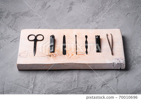 Set of manicure, pedicure tools and accessories on wooden board, stone concrete background, angle view 70010696
