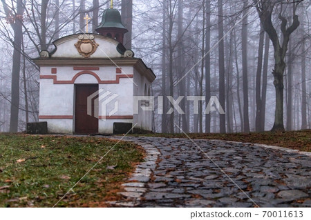 Chapel with stone path in forest with fog. Evening clouds around Chapel, Czechia. Chapel with stone path in forest with fog. Evening clouds around Chapel, Czechia. 70011613
