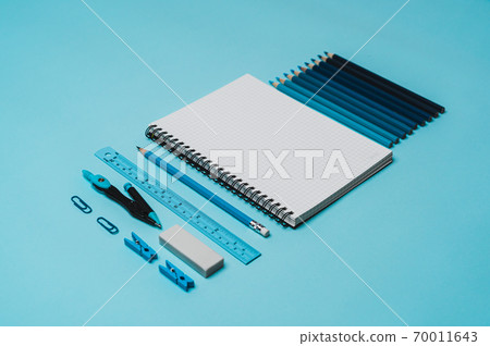 book, pencil, ruler on a blue background. 70011643