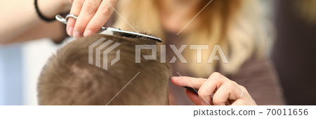 Woman hairdresser cuts man's hair in a beauty salon Woman hairdresser cuts man's hair in a beauty salon 70011656