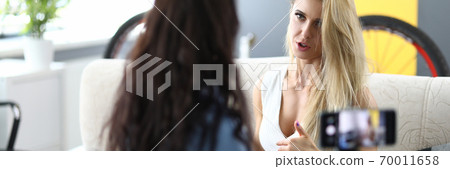 Woman interviews blonde and records it on her smartphone. Woman interviews blonde and records it on her smartphone. 70011658