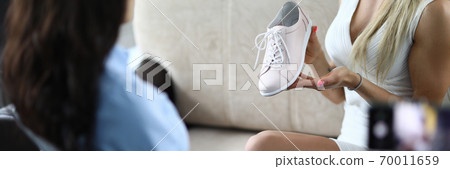 Woman demonstrates her shoes and takes an overview on camera. 70011659