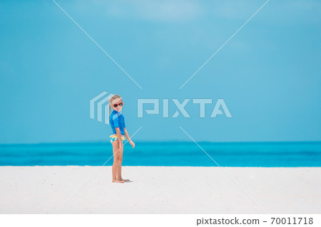 Adorable little girl have fun at tropical beach during vacation Adorable little girl have fun at tropical beach during vacation 70011718