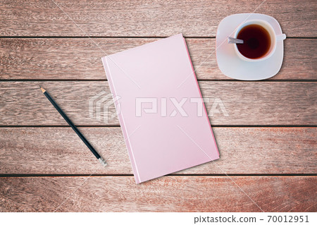 Pencil and a pink covered notebook on wooden table. Bird eye view, mock-up concept. Pencil and a pink covered notebook on wooden table. Bird eye view, mock-up concept. 70012951